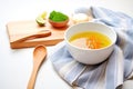 soup in a white bowl, wooden spoon, kitchen towel under bowl Royalty Free Stock Photo