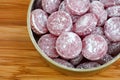 Sour cherry drops. Hard candy with a sour flavor with icing sugar in a tin can