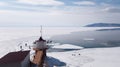 The source of the Angara river from lake Baikal. Spring in Siberia-a group of people walking on ice. Beautiful lighthouse Royalty Free Stock Photo