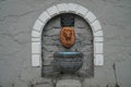 A source of drinking mineral water in one of the Kamenets-Podolsk parks. A sign with the name `Lion`s Mouth`. Royalty Free Stock Photo