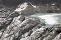 Source of rhone river, glacial lake fall as a waterfall between mountain rocks. High alps landscape of arid terrain Royalty Free Stock Photo