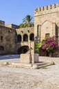 Source of water on the background of the knights Hospitallers in the square Argirokastro. Rhodes Old Town, Greece