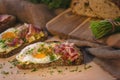 Sourdough bread garnished with fried egg, bacon, chives and parsley.