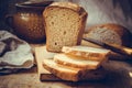 Sourdough bread loaf, sliced on old wood cutting board, vintage crockery, linen towel, authentic rural style