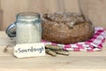 sourdough label with yeast jar, bread, wheat ears on wooden background Royalty Free Stock Photo