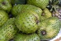 Soursop, Guanabana or Custard Apple or Annona muricata and green coconut on street market in Ubud, island Bali, Indonesia. Closeup