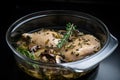 sous-vide chicken cooked in flavorful broth with mushrooms and herbs