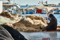 Fisherman repairs his fishing nets at the edge of the Souse harbor basin