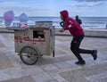 A Tunisian cotton candy seller walks his handcart along the beach promenade in search of customers
