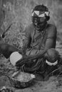 South Africa: a bushmen woman in the Drakensberge opening an oostrich egg