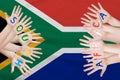 South Africa inscription on the children`s hands against the background of a waving flag of the South Africa Royalty Free Stock Photo