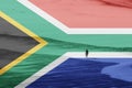 A South African flag with a women walking on a beach in the background. Royalty Free Stock Photo