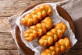 South African Koeksisters deep-fried sticky donut is sweet, sticky, crisp and soaked syrup close-up on a plate. horizontal top vi Royalty Free Stock Photo