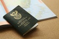 A South African passport next to a world map. Travel and emigration concept image