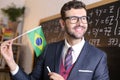 South American educator holding the Brazilian flag in classroom