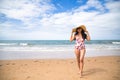 South American woman, young and beautiful, brunette with sunglasses, hat and swimsuit posing happy and smiling on the beach. Royalty Free Stock Photo