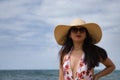 South American woman, young and beautiful, brunette with sunglasses, hat and swimsuit posing happy and smiling on the beach. Royalty Free Stock Photo