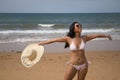 South American woman, young and beautiful, with sunglasses, brunette with bikini and hat with the word summer held in her hand Royalty Free Stock Photo