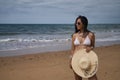 South American woman, young and beautiful, with sunglasses, brunette with bikini and hat with the word summer held in her hand Royalty Free Stock Photo
