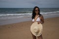 South American woman, young and beautiful, with sunglasses, brunette with bikini and hat with the word summer held in her hand Royalty Free Stock Photo