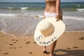 South American woman, young, with bikini and hat with the word summer held in her hand, on her back, running. Concept sea, sand, Royalty Free Stock Photo