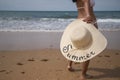 South American woman, young and brunette with bikini and hat with the word summer held in her hand, on her back, running. Concept Royalty Free Stock Photo