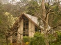 Triangular timber house with various types of trees