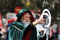 Wizard in a green cloak with a hood with magic rings in his hands. Participant of the local festival, a costume performance at