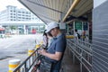 South East Asia / Singapore - Unidentified people using mobile phone surfing Internet while waiting for bus to