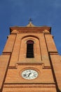 In the south of France near Toulouse, an old clock on the front facade of a red brick medieval church Royalty Free Stock Photo