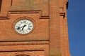 Old clock on the front facade of a red brick medieval church, in the south of France near Toulouse. Royalty Free Stock Photo