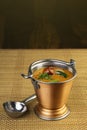 South Indian Curry, Sambar served on a table in a tiny bucket