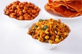 South indian spicy crunchy mix Nimco or Namkeen with peanut, rice, curry leaves and spice white bowl background isolated Royalty Free Stock Photo