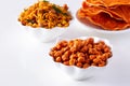 South indian spicy crunchy mix Nimco or Namkeen with peanut, rice, curry leaves and spice white bowl background isolated Royalty Free Stock Photo