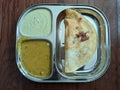 South Indian typical breakfast dosa with sambhar and coconut chutney on a traditional silver metal plate