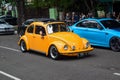 Modified orange Volkswagen Beetle on the road Royalty Free Stock Photo