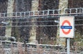 South Kensington tfl underground station and red underground sign in winter during heavy snow