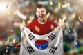 South Korean fan, a fan of a man holding the national flag of South Korea in his hands. Soccer fan in the stadium. Mixed media Royalty Free Stock Photo
