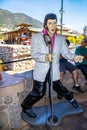 Statue of Elvis singing with microphone and blue suede shoes on sidewilk in South Tahoe with tourist