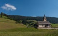 South Tyrolean mountain church under a blue sky with a single white cloud Royalty Free Stock Photo