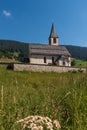 South Tyrolean mountain church under a blue sky with a single white cloud Royalty Free Stock Photo