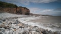 South Wales coastline, showing the water lapping against the rocky shore, flanked by high cliff. Royalty Free Stock Photo