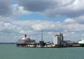 Southampton Docks with big cruise ship and cargo vessel on calm summer day with fine weather blue sky and white clouds