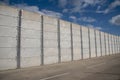 Security wall made of concrete panels topped with wire