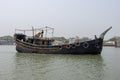 Southeast Asian fisher boat running through a river. Old wooden fishing trawler side view. Beautiful rural life and waterway Royalty Free Stock Photo