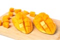 Fresh hedgehog style Mango preparation, cubes and chunks on wooden cutting board, isolated on a white background.