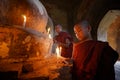 Southeast Asian neophytes light candles inside a Buddhist temple