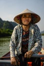 Southeast Asian woman paddling a boat to Thien Tru Temple and the Perfume Pagoda in Hanoi, Vietnam Royalty Free Stock Photo