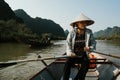 Southeast Asian woman paddling a boat to Thien Tru Temple and the Perfume Pagoda in Hanoi, Vietnam Royalty Free Stock Photo