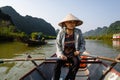 Southeast Asian woman paddling a boat to Thien Tru Temple and the Perfume Pagoda in Hanoi, Vietnam Royalty Free Stock Photo